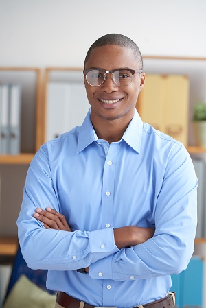 Portrait of confident smiling businessman standing with his arms crossed